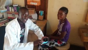 A clinical officer in rural Zambia uses The Virtual Doctors' custom app on a laptop to help diagnose a child's illness. The programme has since moved from laptops to smartphones.